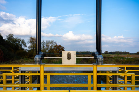 Yellow Rail Water Gate Mechanism Above Flowing Water With Blue Sky For Engineering And Water Management Useの写真素材