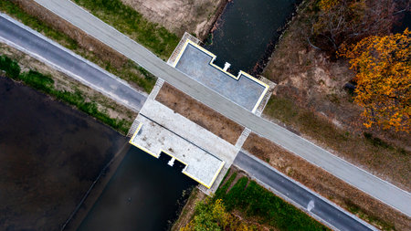 Aerial View Of Water Canal Intersection With Road And Pathways For Engineering And Infrastructure Planningの写真素材