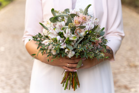 Bride Holding Elegant Wedding Bouquet With Soft Pastel Flowers For Romantic Celebration Themesの写真素材