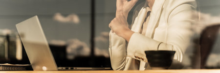 Woman Working On Laptop In Cafe With Reflections On Window During Phone Conversation. Copy Space. Businesswoman Web Bannerの写真素材