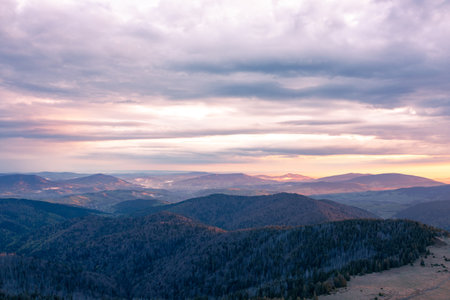 Mountain Ridge And Rolling Hills Under Soft Sunset Light With Expansive Scenic Viewsの写真素材