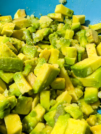 Freshly Cut Avocado Pieces In Bowl Showing Bright Green Textureの写真素材