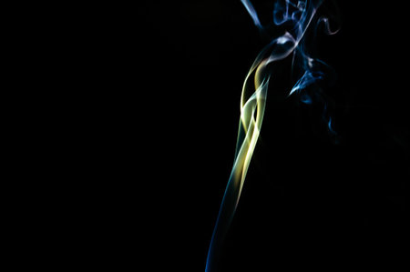 Colorful Smoke Trail Rising Against Black Background Creating Abstract Artistic Pattern. Creative Long Exposure Photo.の写真素材