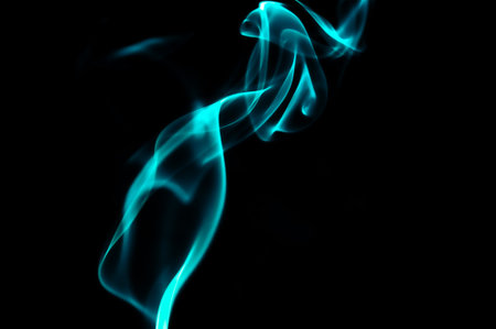 Turquoise Smoke Pattern In Black Bancground Creating Fluid Abstract Shapes And Elegant Flow. Unique Long Exposure Photo Ideaの写真素材