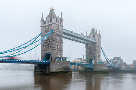 Tower Bridge London In Fog Over River Thames Highlighting Historic Architecture And Urban Waterfrontの写真素材
