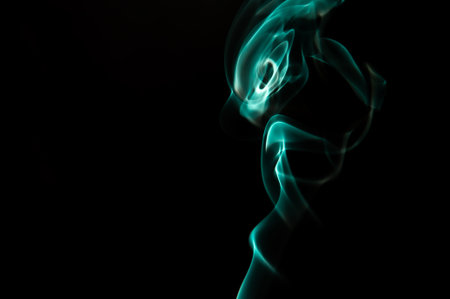 Blue Smoke Pattern In Dark Studio Forming Abstract Fluid Shapes With Soft Light Accentsの写真素材