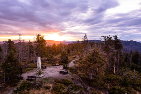 Mountain Summit At Sunset With Scenic Viewpoint And Vibrant Sky Over Forested Hillsの写真素材