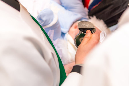 Baby Baptism Christening With Priest Pouring Water, Church Religion Ceremony Holy Sacrament Momentの写真素材
