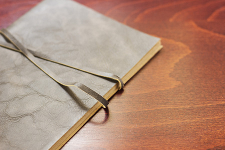 Notebook with leather cover on the wooden desk