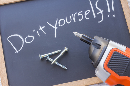 "Do it yourself" written on a blackboard and a electric screwdriverの写真素材