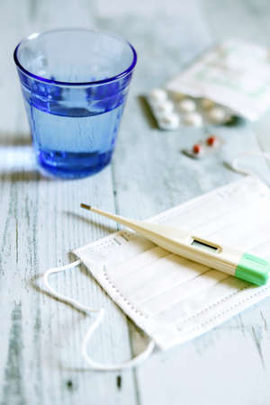 Recovery at home, a surgical mask, a thermometer and tablets
