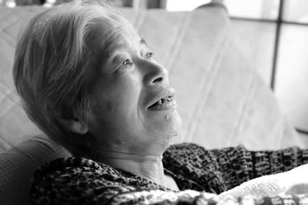 Elderly woman reclining on the nursing bed, close-up portraitの写真素材