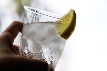 Female hand holding a glass filled with highballの写真素材