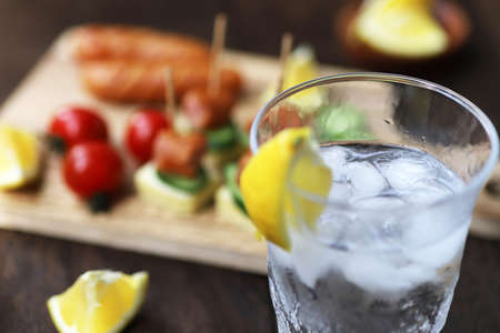 A Glass filled with whiskey soda and finger foodsの写真素材