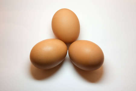 Three eggs positioned in a triangular shape isolated on whiteの写真素材