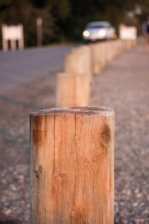 Short wooden posts in a line that serve as a barrier on a roadの写真素材