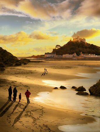 Beautiful evening at St Michael's Mount Cornwall, a family take a walk to watch the sun set and spot two children with their dog,,の写真素材