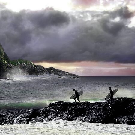 The surf is up and its going to be a great surf day, two surfers rush to the beach to catch the perfect wave,の写真素材
