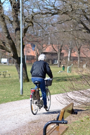 An elderly man cykling in park at springの写真素材