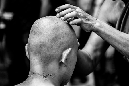 shaving hair of person about to be ordained as a Buddhist priest in Thailandの写真素材