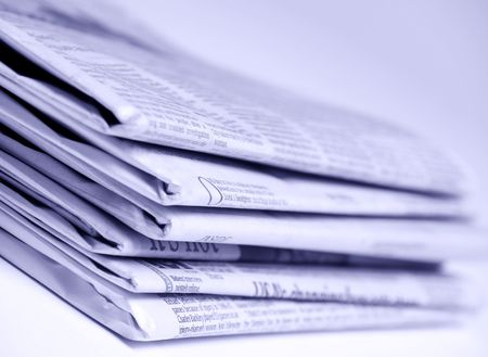 Blue tinted newspapers on light background shot with very shallow depth of focusの写真素材
