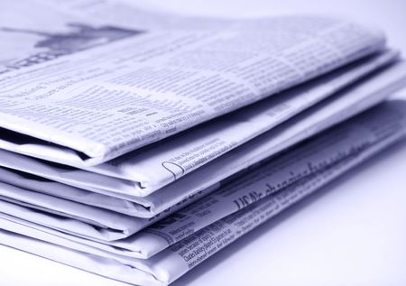 Blue tinted newspapers on light background shot with very shallow depth of focus