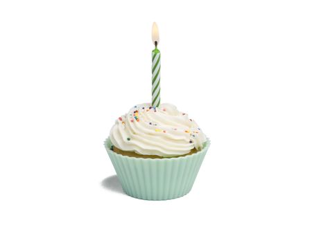Green cupcake with candle on white background