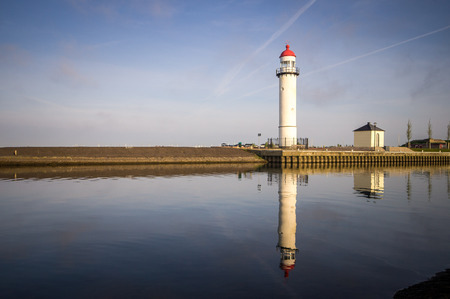 Lighthouse reflected in waterの写真素材