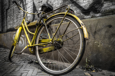 Yellow bicycle in a grungy alleyの写真素材