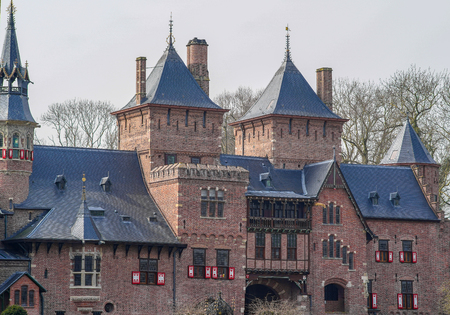 Fragment of an ancient castle showing old brickwork, windows and red and white shuttersの写真素材