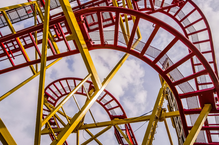 Bottom view of the construction of a roller coaster with red and yellow bars. This kind of attractions is often seen at fairsの写真素材