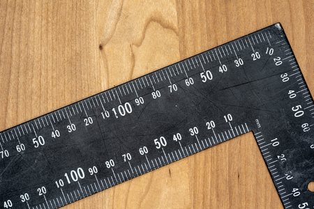 Tools that can be used by a carpenter are displayed on a woorden taebel. These can be a hamer, measuring tape, protective gloves and a sawの写真素材
