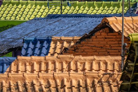 A neighborhood with houses with brightly colored facades and roofs. Even the roof tiles are painted...