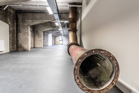 Interior of a former factory that has been restored. The old constructions and brick walls are visible, supplemented with restored and new parts. It continues to give a grungy and rundown impression.の写真素材