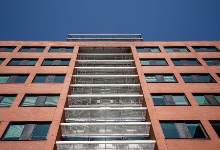 Red brick facade of a corporate building under a blue sky