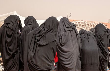 OUARZAZATE/MOROCCO - APRIL 19 2017: Women in traditional clothing at a typical Moroccan market in the desertの写真素材
