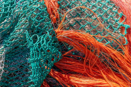 Close up of a colored fishing nets drying in the sun red, green and purpleの写真素材