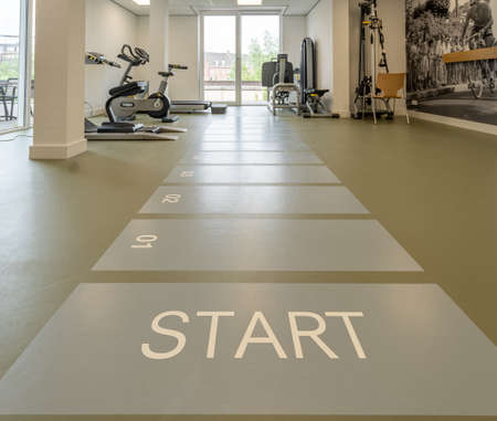 BREDA / NETHERLANDS - JUNE 22, 2021: Various fitness and cardio equipment in a gym room. This keeps...
