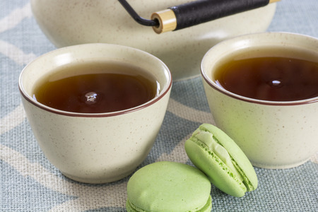 two cups of fresh strong tea and macaroon cookiesの写真素材