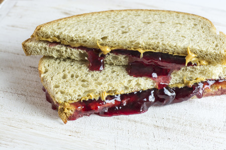 Closeup of peanut butter and jelly sandwiches on a wood.