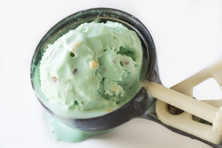 Closeup of  melting ice cream scoop in metal spoon.の写真素材