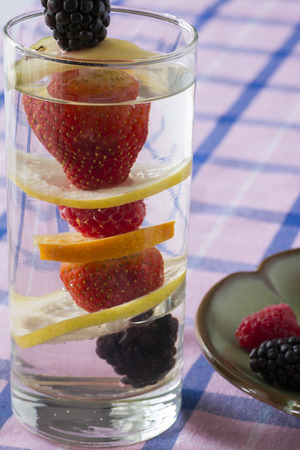 Closeup of glass of assorted berries and fruits infused water.の写真素材