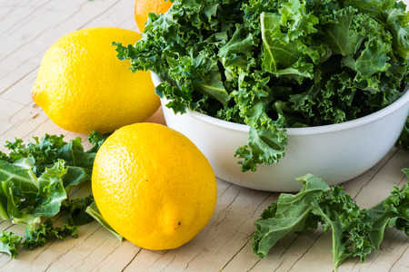 Closeup of bowl with fresh cut kale and orange and lemon - ingredients for cold breakfast pops.の写真素材