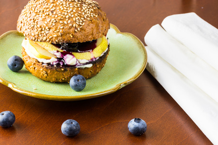 Close up of cheese, pear and blueberry jam sandwich with toasted wheat roll.の写真素材