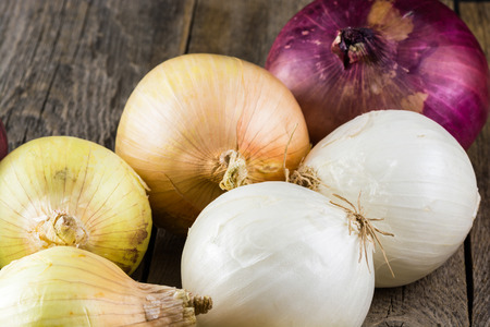 Close up of assorted onions on a wood.の写真素材