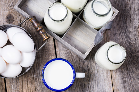 Close up of bottles with milk  and eggs in basket.の写真素材