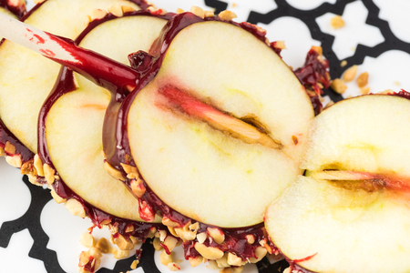 Close up of sliced candy apple with nuts on a cut board.の写真素材