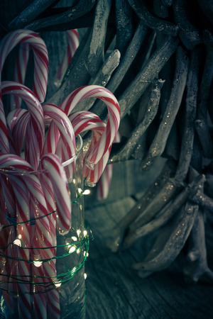 Close up of Christmas decoration with candy canes in glass and mini lights.の写真素材