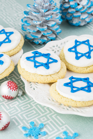 Close up of cookies decorated with blue stars -  Hanukkah symbol on a white plate.の写真素材
