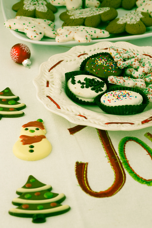 Close up of assorted Christmas cookies on a white plate decorated with a red ribbon.の写真素材